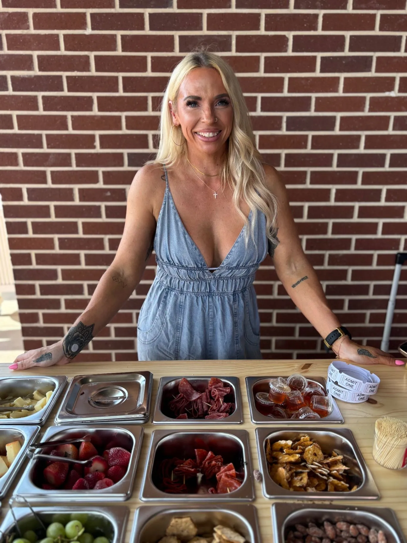 Jess standing behind a fully stocked charcuterie spread at a celebration