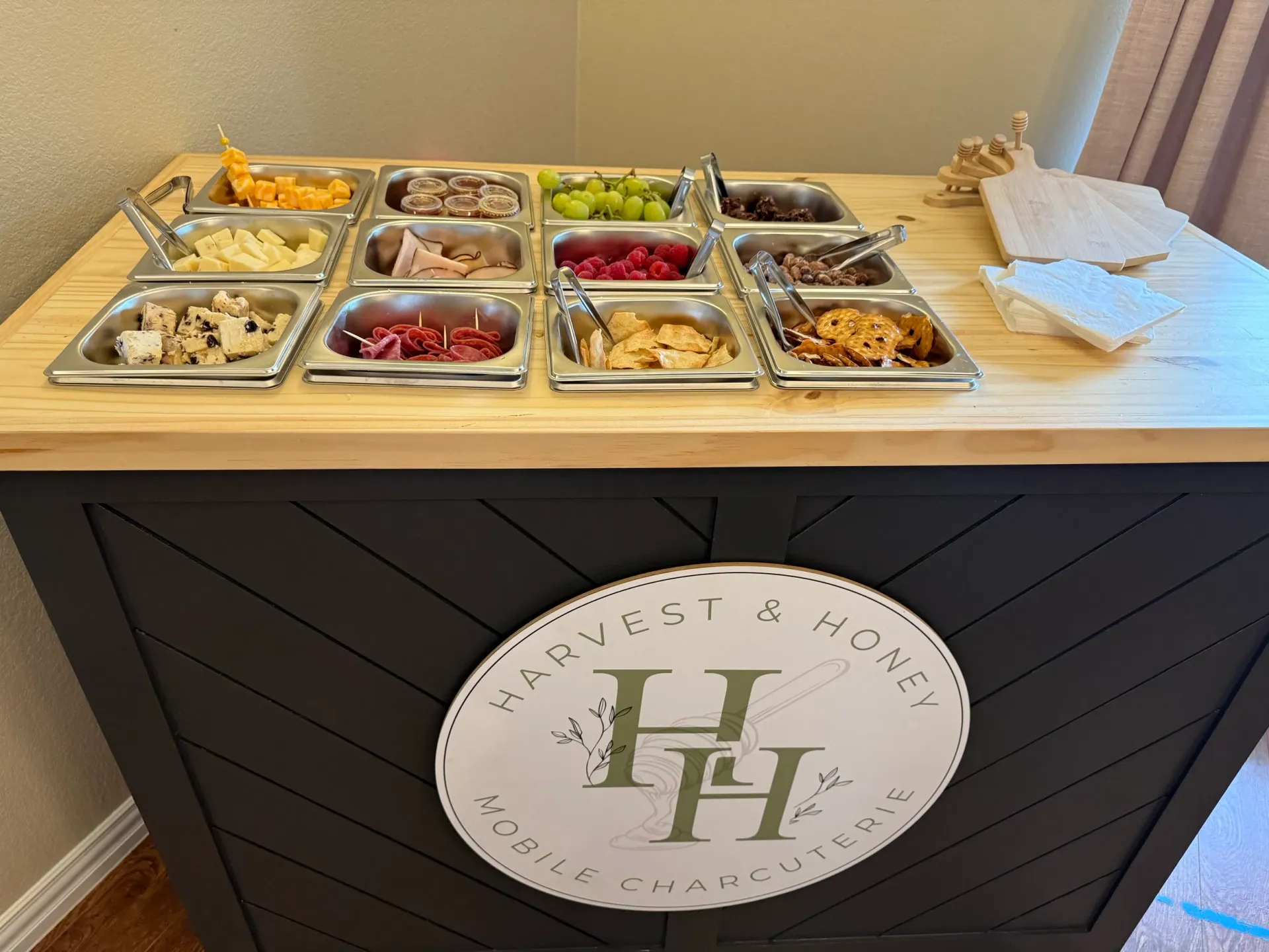 Harvest & Honey mobile grazing cart stocked with cheeses, meats, fruit, and crackers